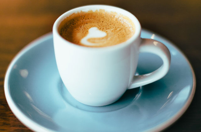 Espresso mit Latte-Art-Herz in weißer Tasse auf weißer Untertasse