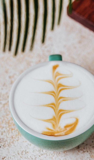 Latte Art Cappuccino in türkiser Tasse
