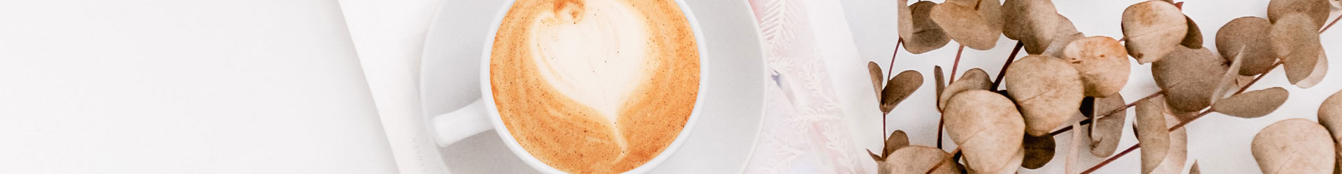 Latte-Art-Herz Cappuccino in weißer Tasse auf einem Buch