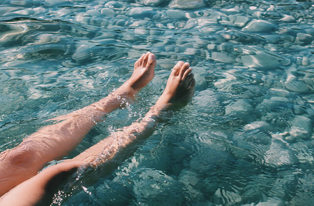 Im türkisen Wasser schwimmende Beine